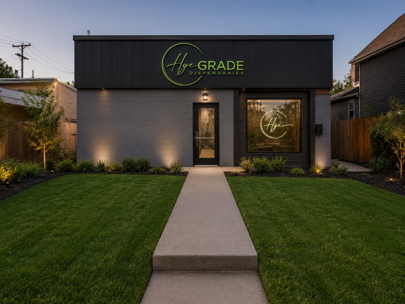 The Hye Grade Dispensaries storefront at dusk on Northeast Central Avenue, with the illuminated Hye Grade sign, a lit walkway, and manicured lawn.